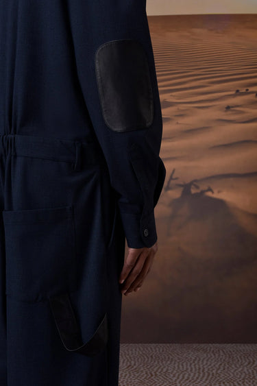 Navy utility-style jumpsuit with tailored silhouette and front button closure