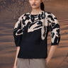 Black fitted top with abstract brushstroke sleeve detailing and tailored silhouette